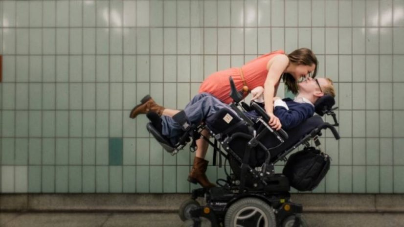 Woman Kissing Boyfriend in Wheelchair