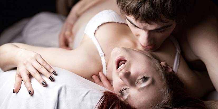 Couple In Bed Engaging In Foreplay