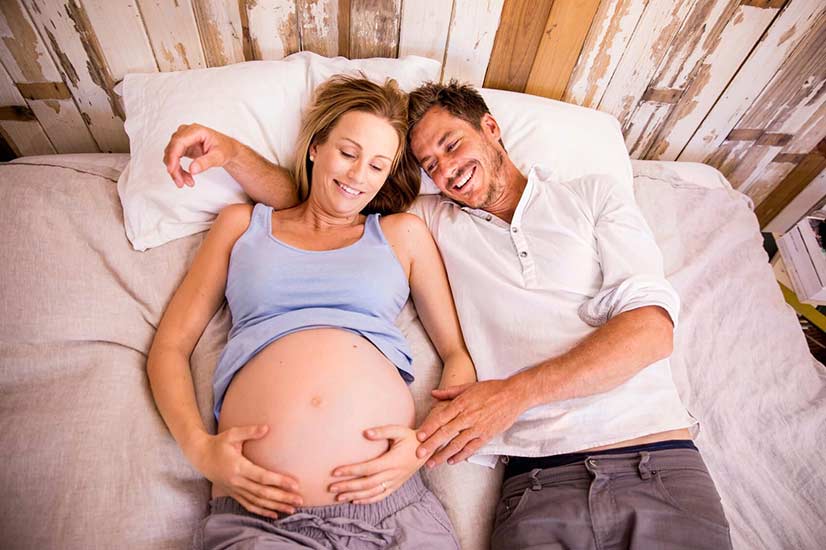 Pregnant Couple In Bed
