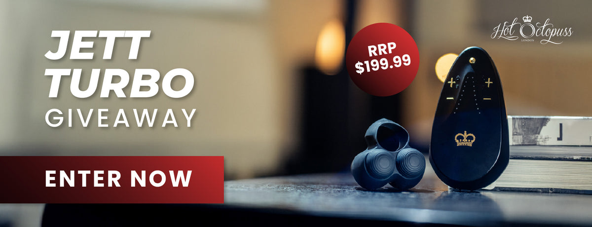 Promotional banner for a 'Jett Turbo Giveaway' by Hot Octopus, featuring a pair of dark blue wireless earbuds and a matching dark blue remote control on a tabletop with a warm, blurred background. The text 'JETT TURBO GIVEAWAY' and 'ENTER NOW' are displayed prominently, along with a red price sticker showing 'RRP $199.