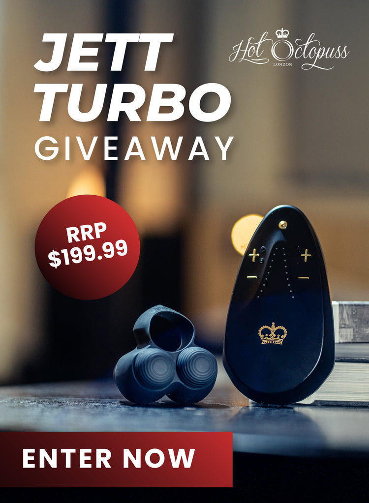 Promotional graphic for a Jett Turbo Giveaway by Hot Octopuss, showing a black personal massager and a blue attachment piece on a dark surface with a blurred indoor background. Large text reads 'JETT TURBO GIVEAWAY' with 'RRP $199.
